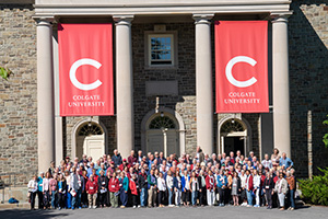 Alumni posing for a photo in front of a Colgate building